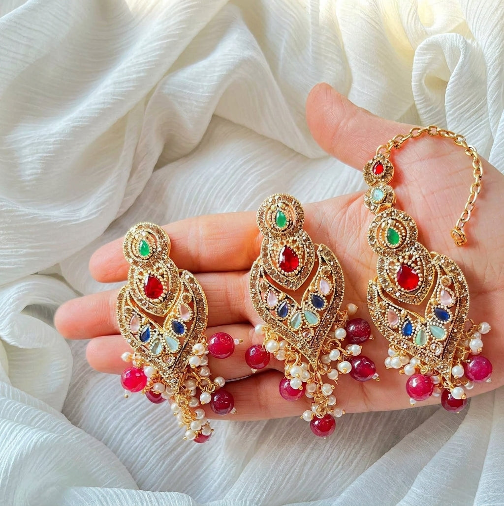Harmony of green, red, blue, mint, and pink stones arranged in sculpted gold filigree.Densely clustered mini pearls and translucent ruby bead drops that create graceful movement.Matching center forehead piece connected by an adjustable golden chain.