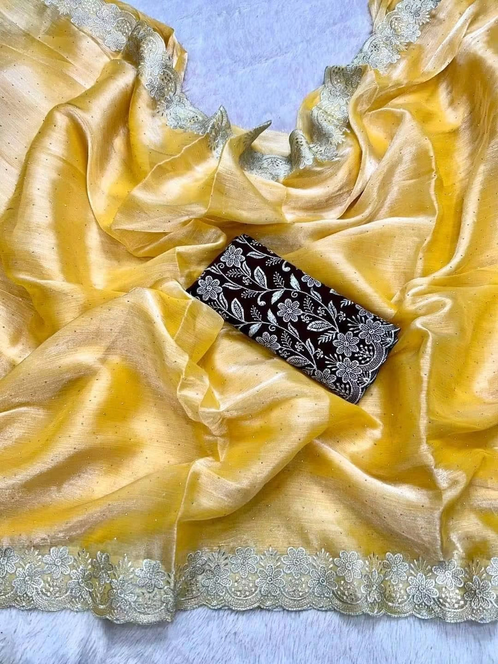 Featuring a Premium Jimmy Choo Silk Designer Saree with Unstitched Blouse Piece.Vibrant Yellow with Silver Embroidery & Contrast Blouse.All-Over Scattered Stone Work with Heavy Thread/Zari Scalloped Border