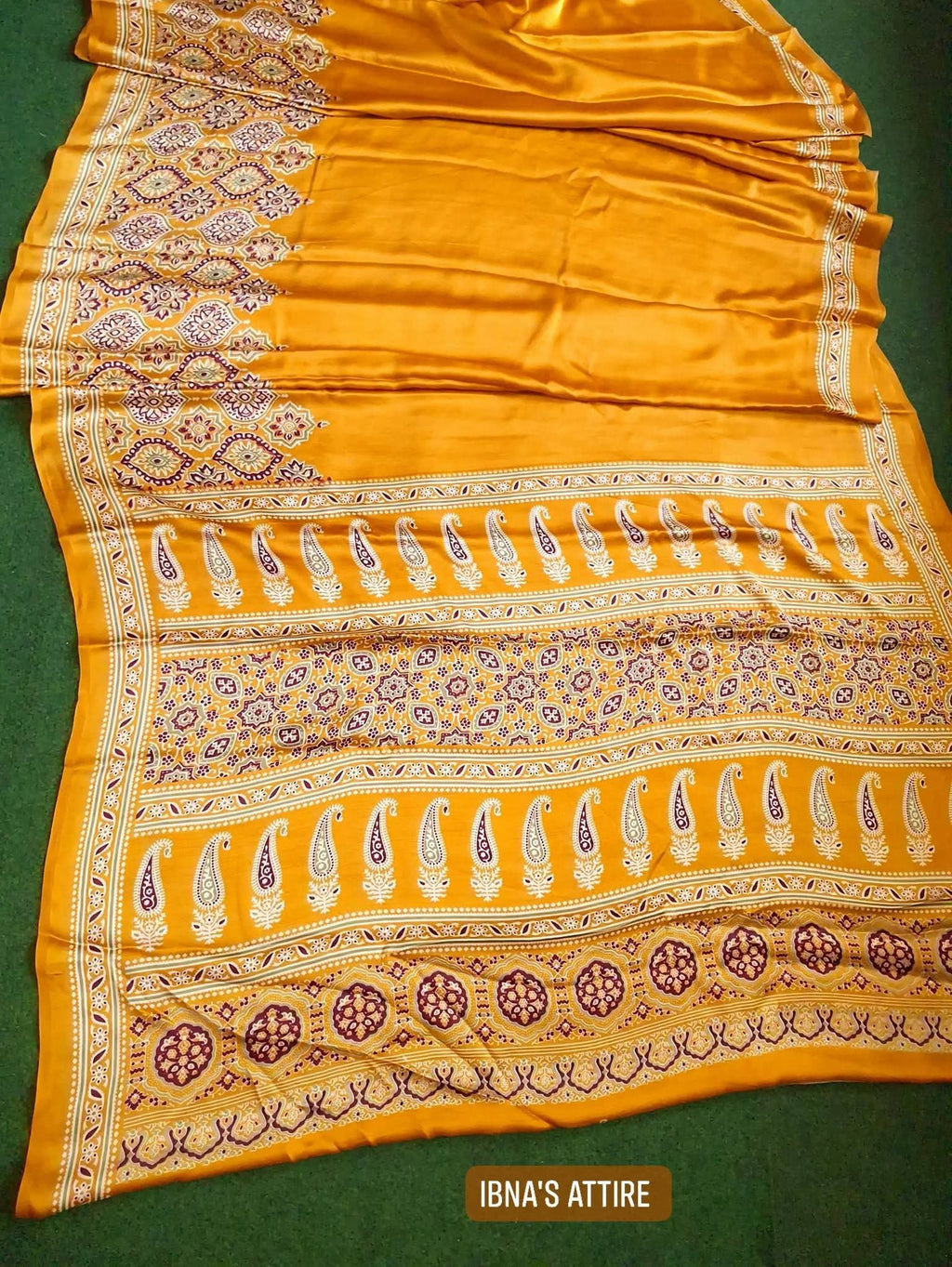 Yellow saree with intricate patterns on a green background