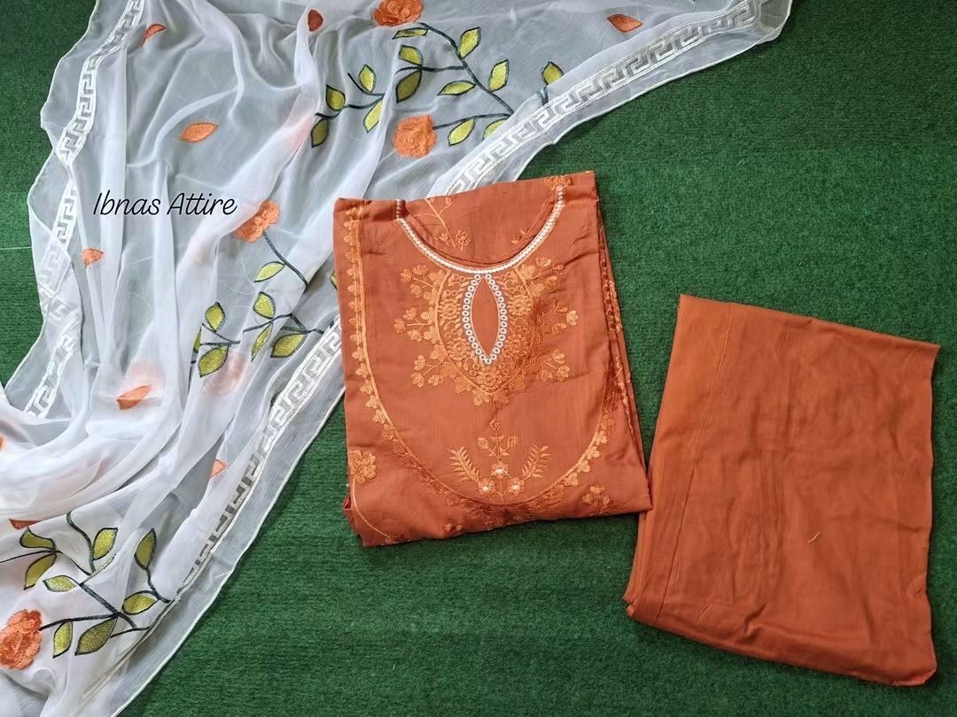 Featuring A Traditional Pakistani Lawn Kurti & Pant Set-Tone-on-tone threadwork that adds texture and refined detailing to the solid rust orange lawn base.A sheer white georgette dupatta featuring vibrant orange floral and leaf embroidery that acts as a stunning statement piece.Clean, plain pure lawn pants to balance out the detailed top and dupatta.