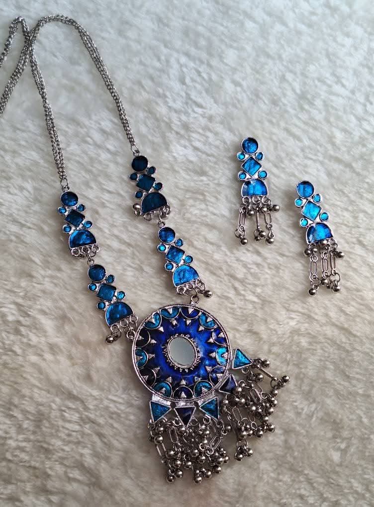 A silver tones oxidized necklace set and earring in blue color in a white background 