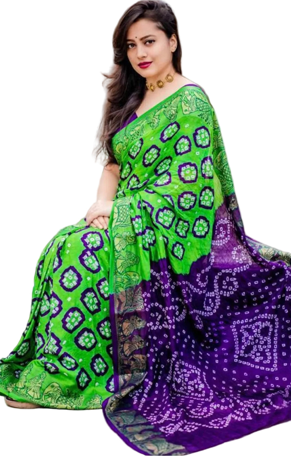 Woman wearing a green and purple patterned saree sitting on steps.