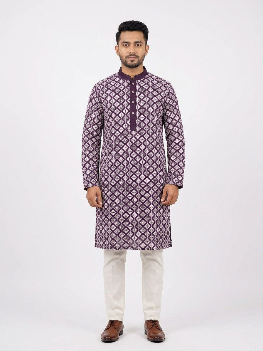 Front facing full-length shot of a man wearing a deep purple soft silk kurta with all-over white geometric embroidered diamond patterns, paired with white trousers and brown dress shoes.Dark purple solid Mandarin collar and placket that balance the detailed body embroidery.
