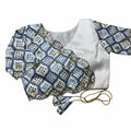 White silk boutique blouse mirror work on a white background sleeves on a gray surface