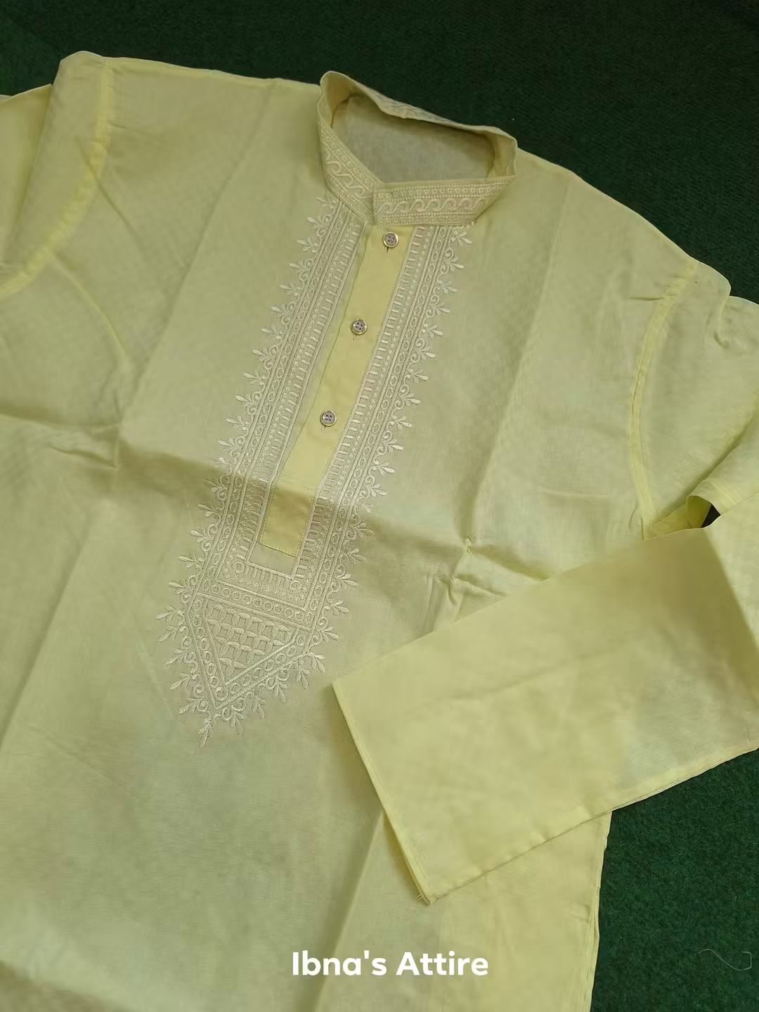 Soft lemon yellow panjabi / kurta with intricate white embroidery on a dark green background