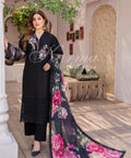 Model posing in a classic black Pakistani lawn long shirt with chikan kari hem details, black trousers, and a dark floral printed khaddi lawn dupatta.Detailed threadwork on a deep black canvas with colorful floral motifs on the neckline and sleeves.High-end craftsmanship along the hemline and sleeves for an artistic textured finish.contrasting, vibrant floral print on dark fabric bordered with delicate lace trim.
