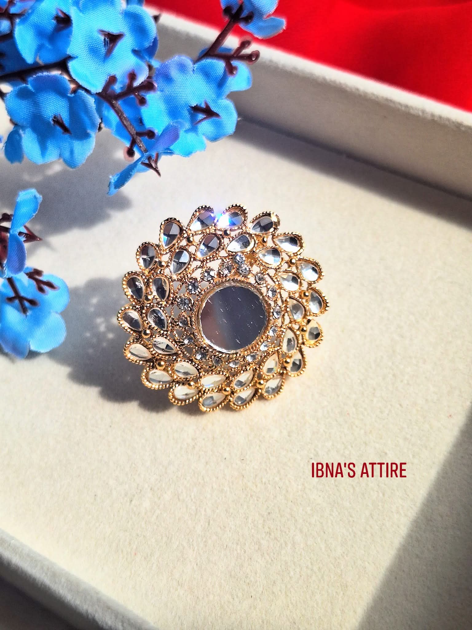 Gold plated mirror cut Adjustable ring with intricate design on a textured surface