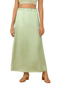 A model wearing a light pista green satin petticoat maxi skirt with a matching crop top, shown against a solid white background.