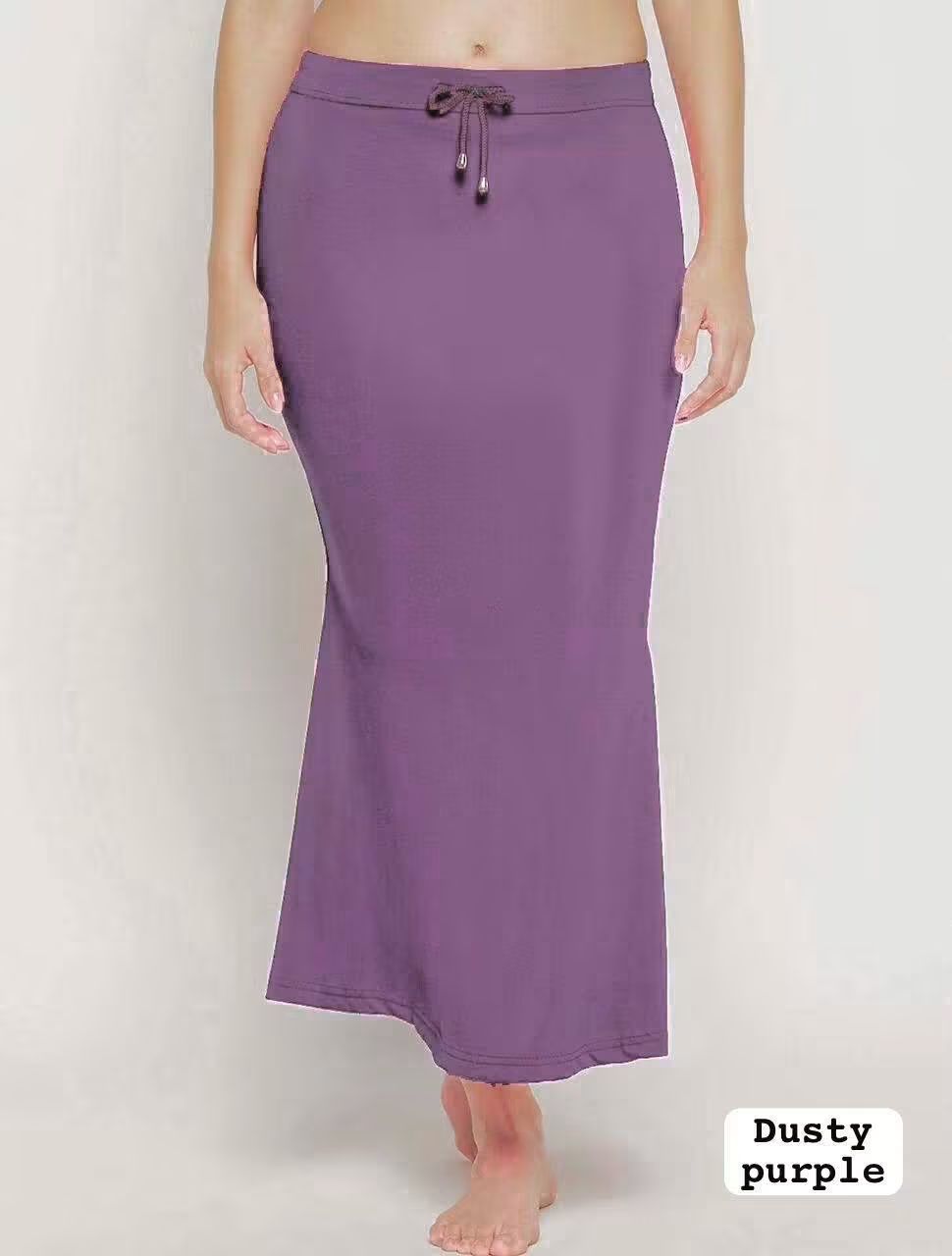 A woman modelling a inskirt in dusty purple color - fabric- heavy Stretchable Lycra  on a white background 