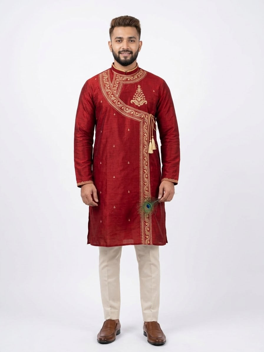 Full-length front view of a man wearing a crimson maroon pure silk Angrakha kurta with gold zari embroidery and tassel ties, paired with off-white trousers.  