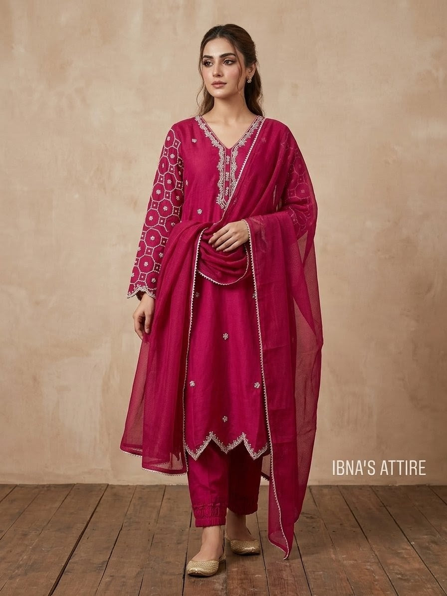 Woman wearing a pink traditional outfit with intricate designs on a beige background