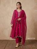 Woman wearing a pink traditional outfit with intricate designs on a beige background