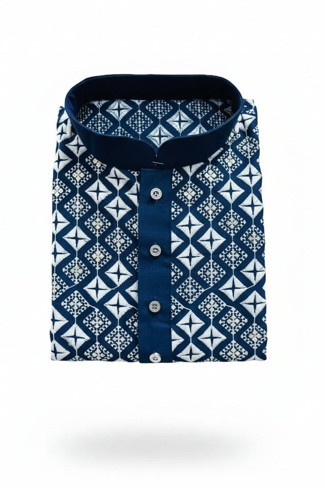 Folded blue silk kurta, white geometric embroidery with sequence details, button placket, held by a hand wearing a watch.