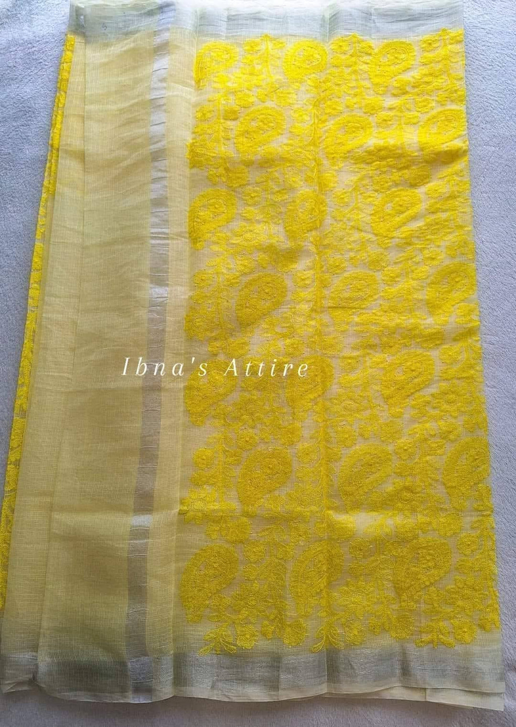 A yellow lakhnouvi work pure kota saree on a white background 