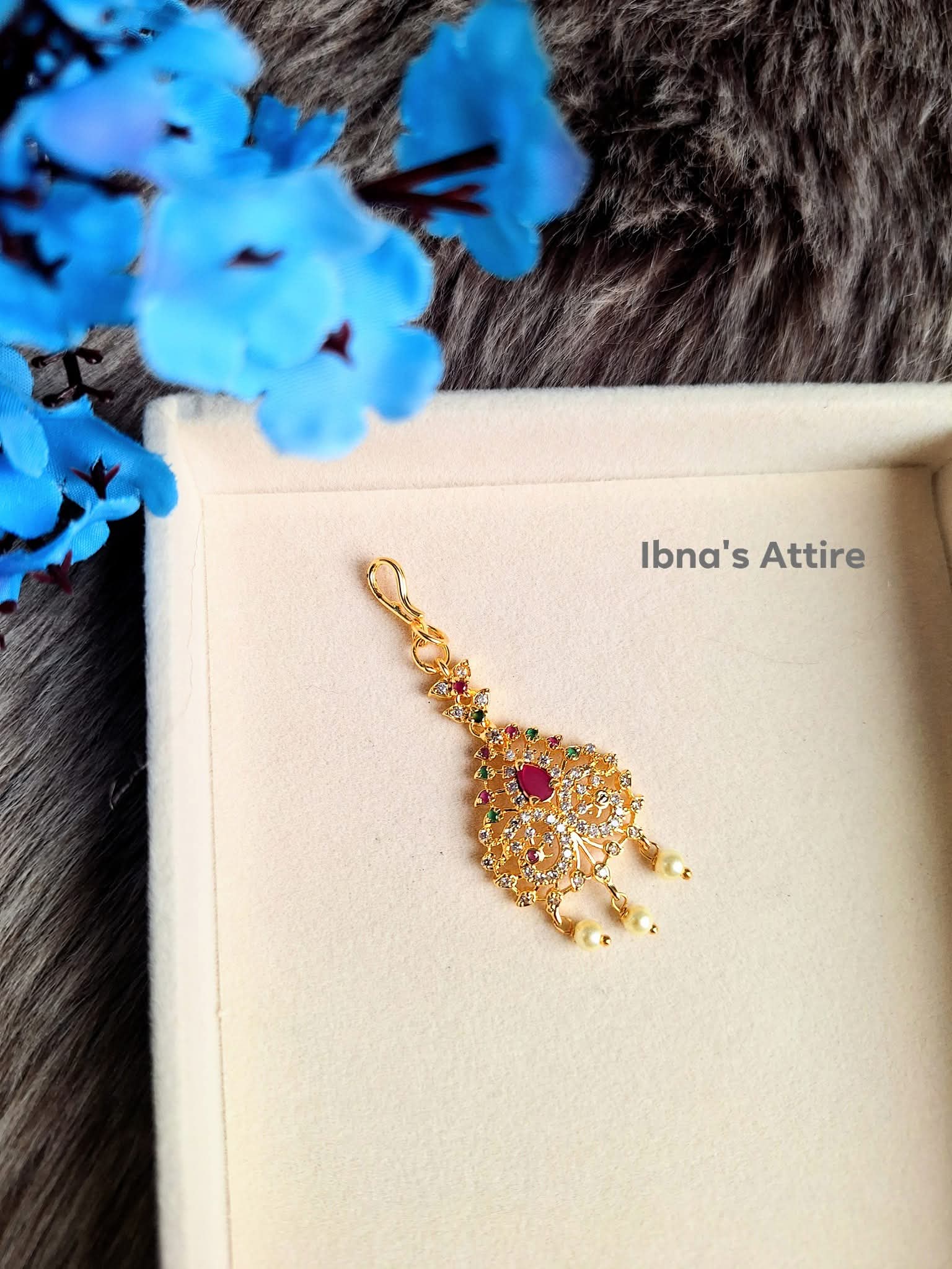 Gold plated American Diamond head piece on a beige color jewelry display box