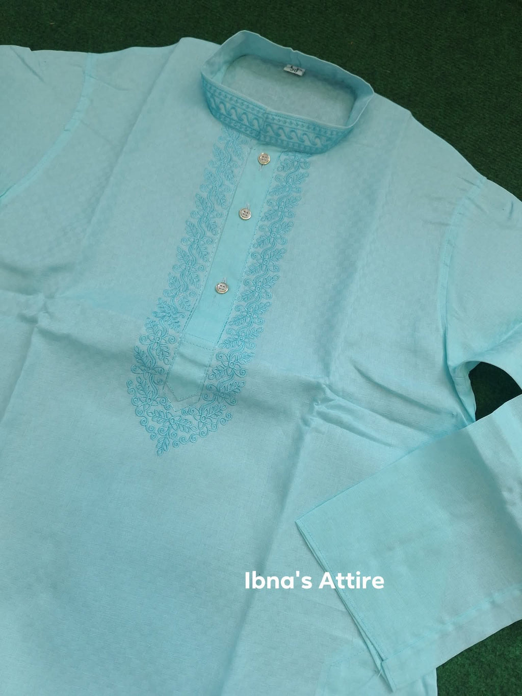 Light blue embroidered handloom cotton panjabi on a green background
