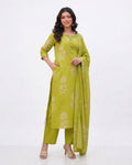 A woman modeling a lime green Traditional Jaipuri Cotton 3-Piece Suit-Delicate shimmering embroidery details along the neckline and yoke to catch the light.Traditional Jaipuri block-style prints embedded seamlessly into the soft green cotton fabric.Ultra-soft, lightweight cotton-mulmul dupatta providing a graceful and effortless drape, against a white background. 