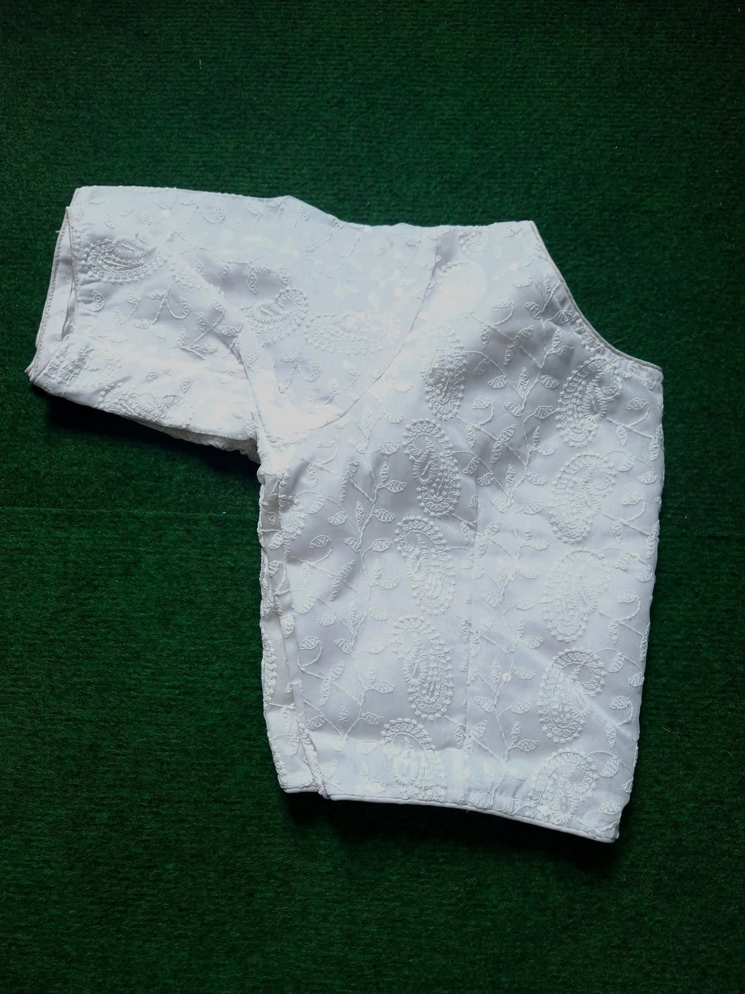 Soft Georgette Chikankari Blouse white color lying on a greeny background 