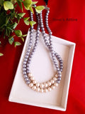 Pearl necklace on a white box with a red background
