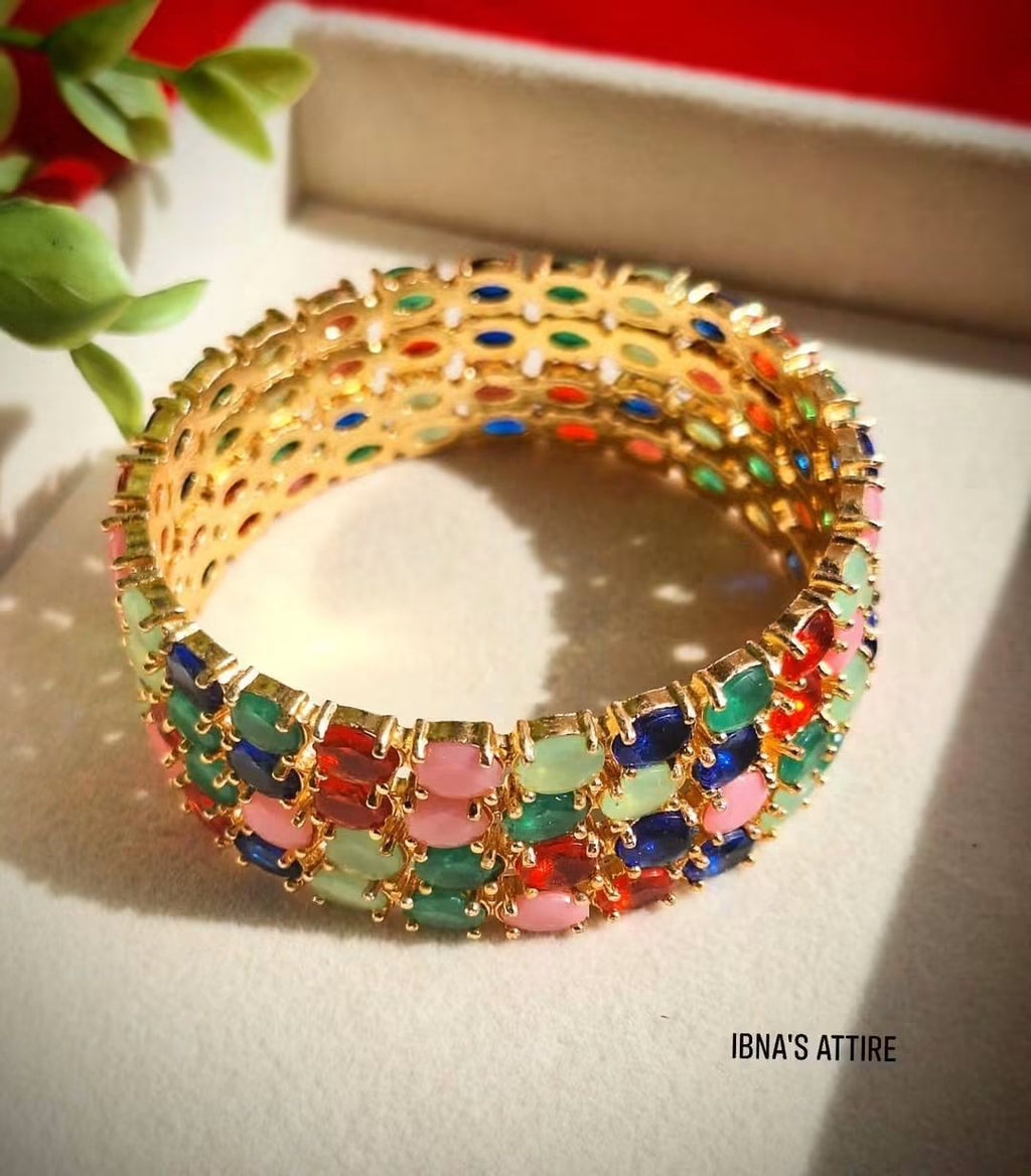 4-Piece Gold Plated AD Bangles Set.Rich golden metal plating offering a classic, high-end contrast.Closely fitted multi-color jewel-toned stones delivering continuous sparkle all around.