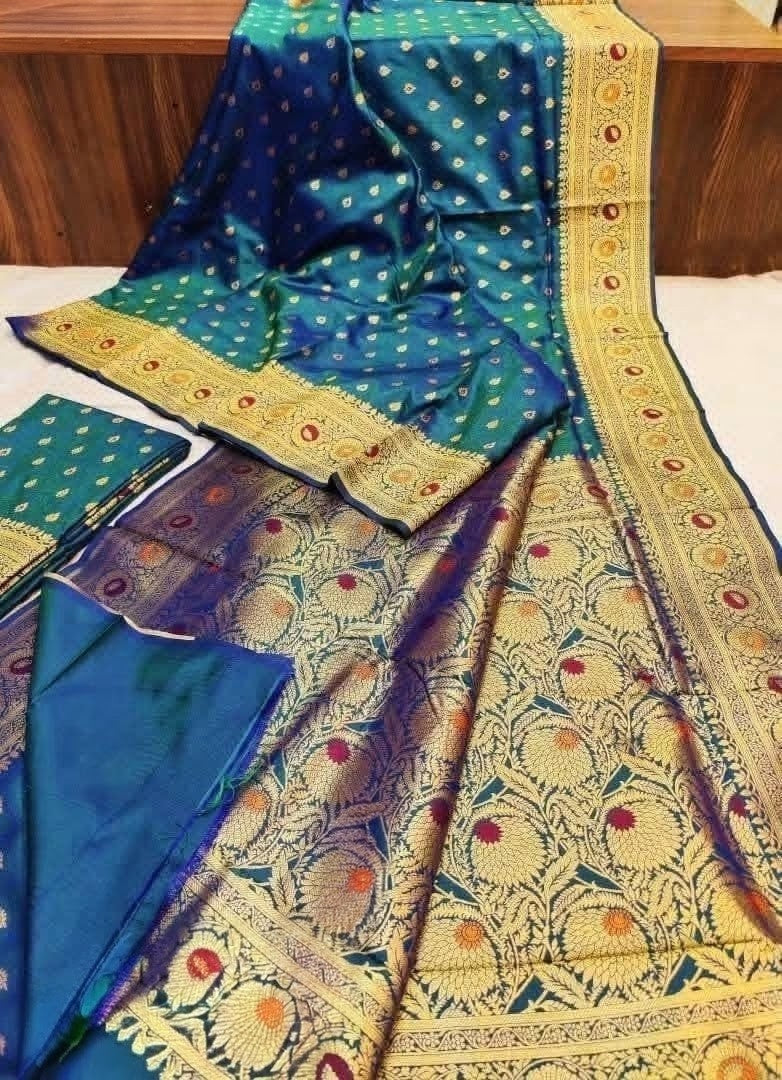 Teal/navy dual tone silk, multi-color mina floral pallu, gold zari border, folded blouse piece layout.