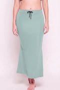 Mint green skirt worn by a person on a light pink background